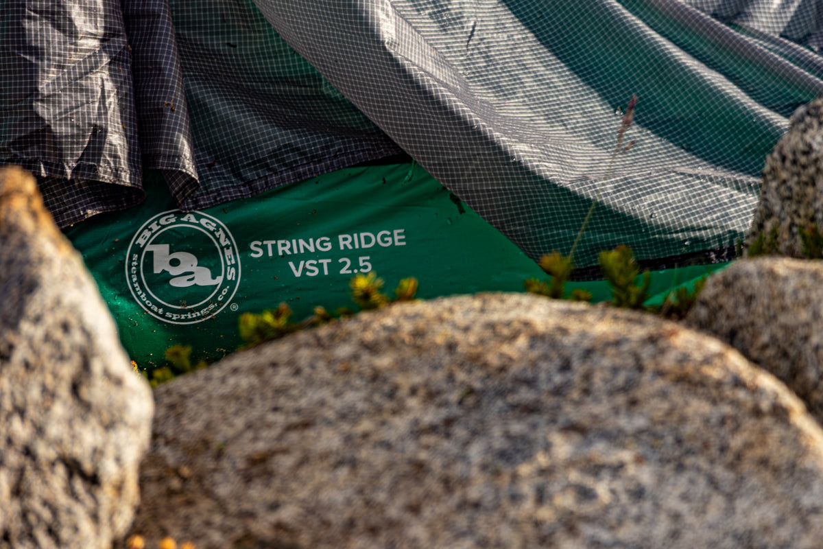 Green Big Agnes tent on rocks with branding visible