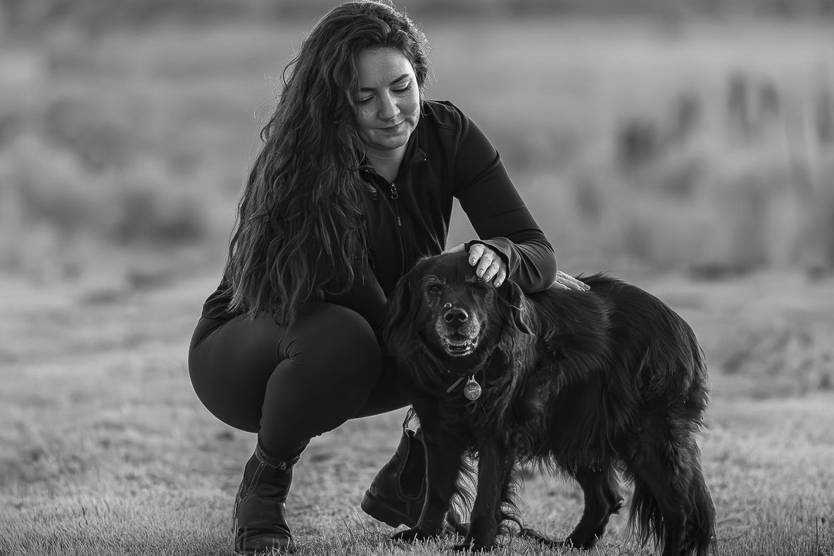 Woman and dog in a field with a blurred background