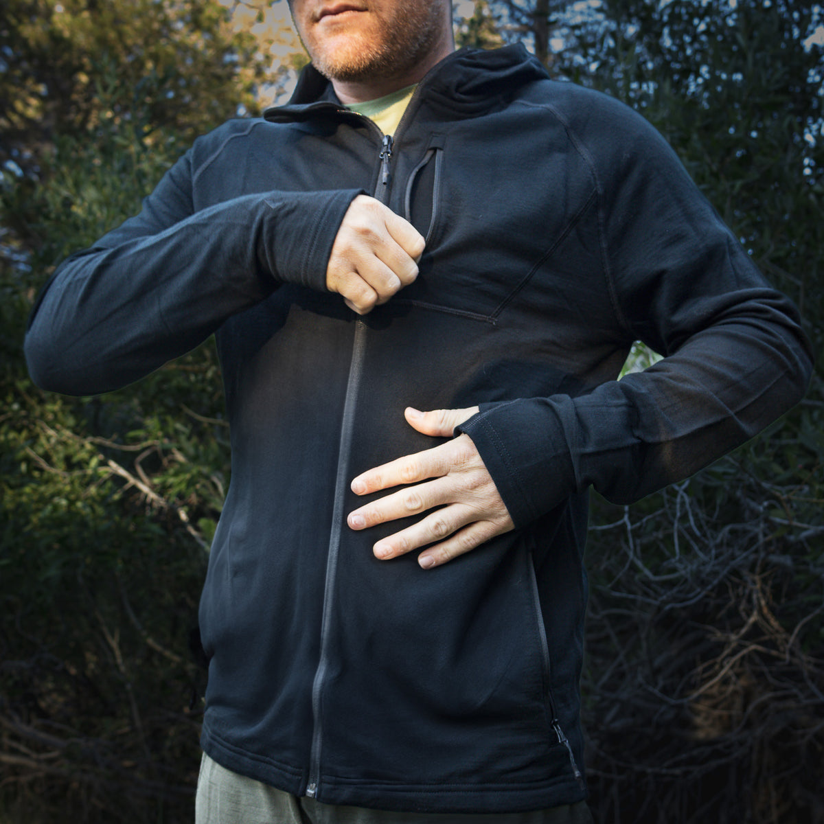 Man wearing a black jacket in a forest setting