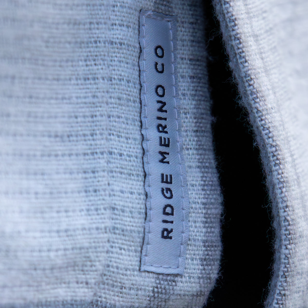 Close-up of a Ridge Merino Co label on a textured fabric background