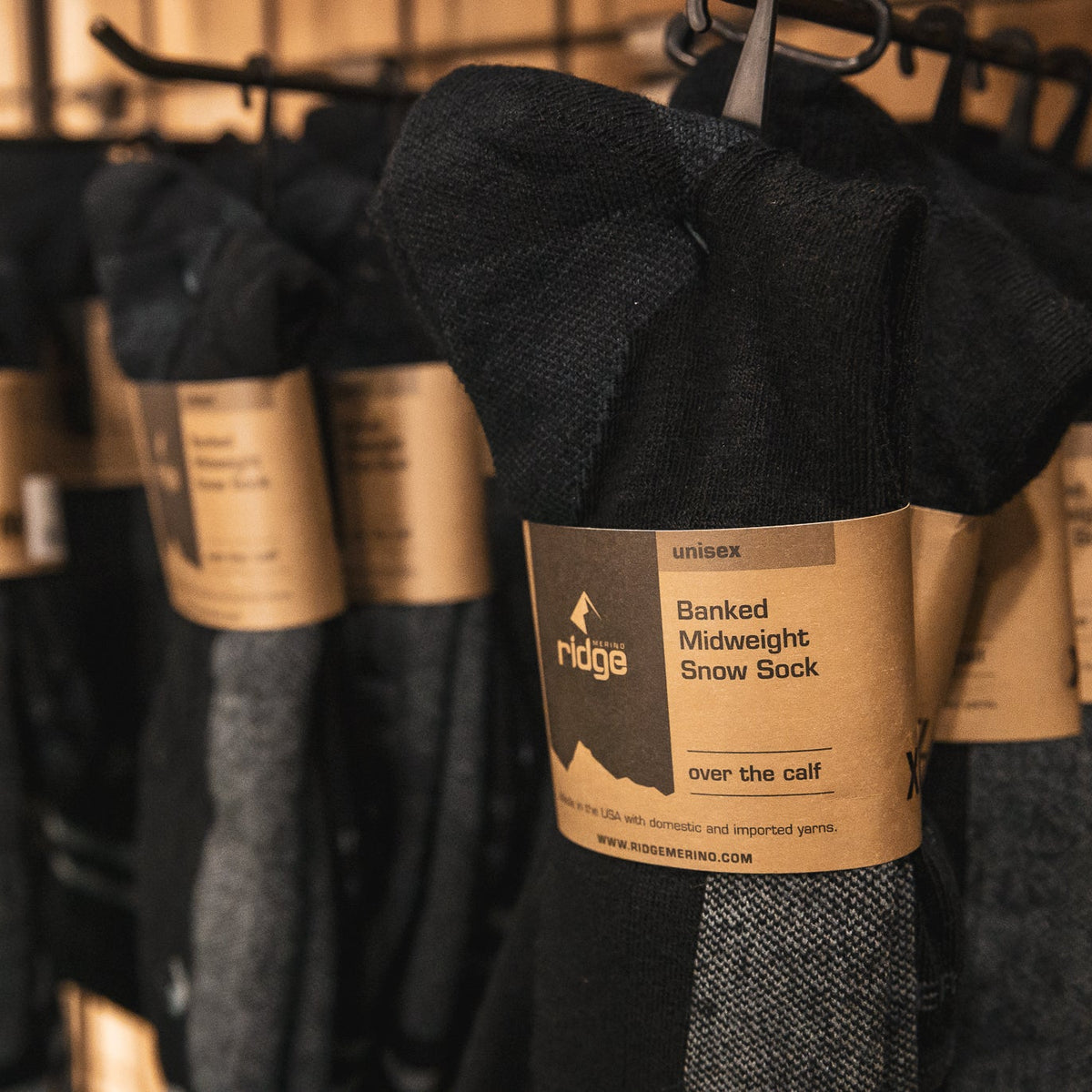 Row of black socks with visible 'ridge' label on a rack.