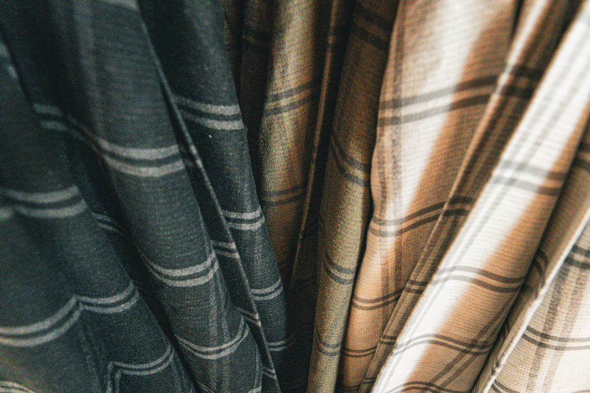 Close-up of plaid fabric in green and brown tones.